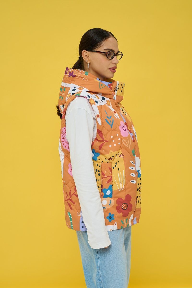 Women's insulated orange vest with an 'Ethnic Cats' print